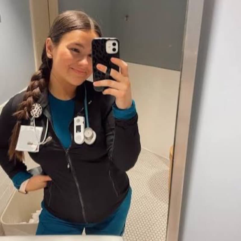 Nursing student with a stethoscope smiling in her clinical scrubs